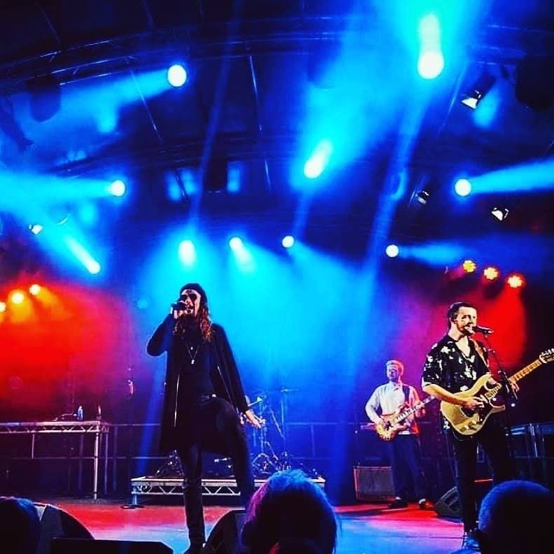 Vocalist and band under blue stage light