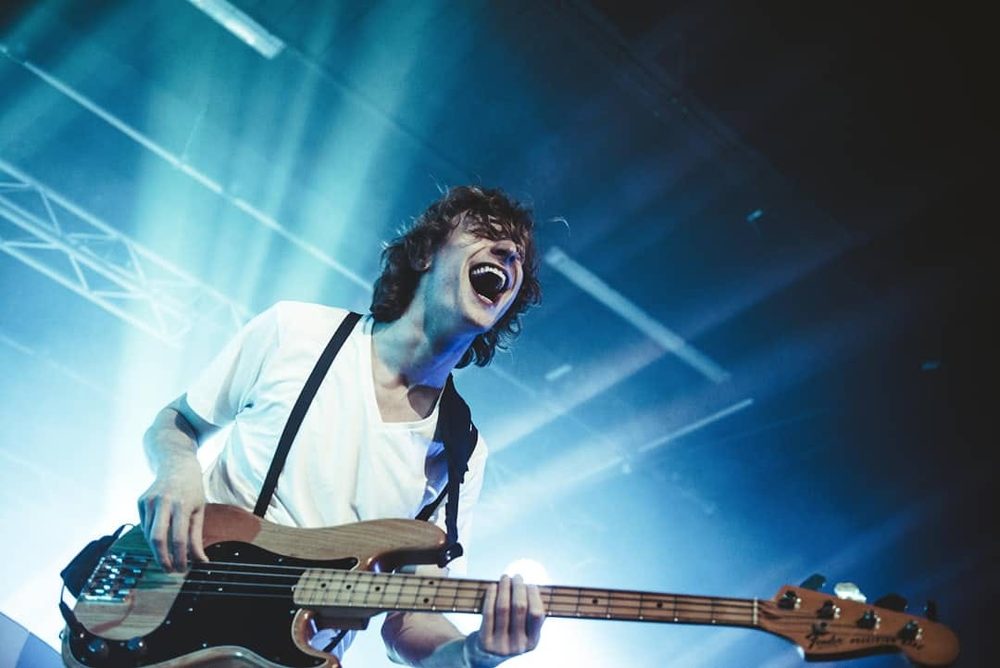 Freddie playing bass under blue stage light