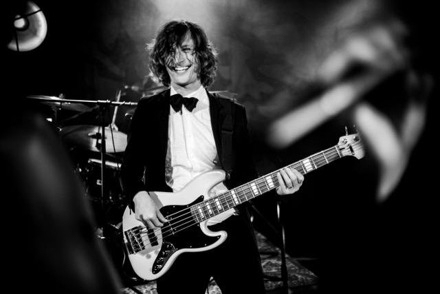 Freddie in black tie playing bass at a function